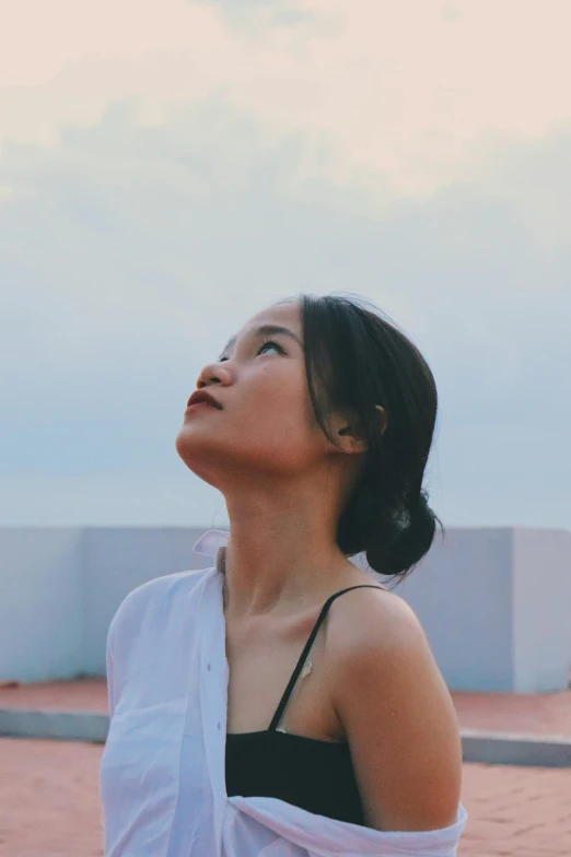 a woman with short hair is standing near a building