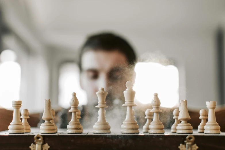 the man is standing in front of the chess game