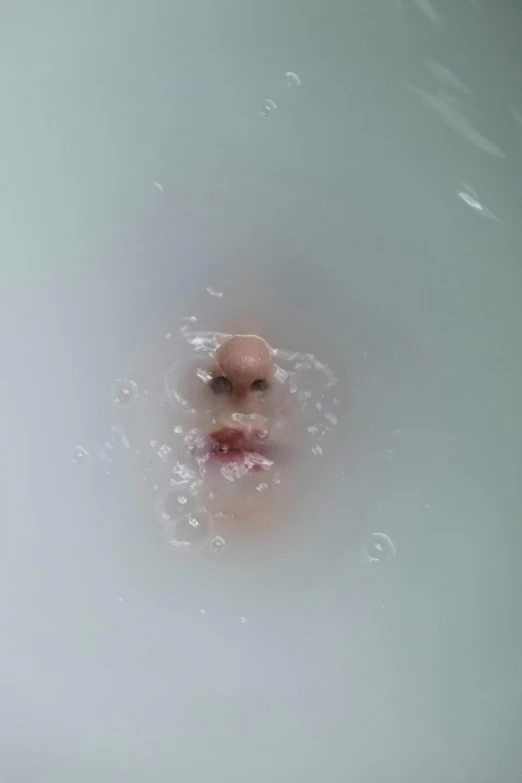 an overhead view of a person looking in the middle of a round bath tub