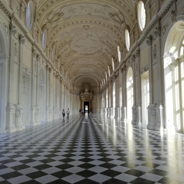 an elegant hallway lined with large windows and pillars