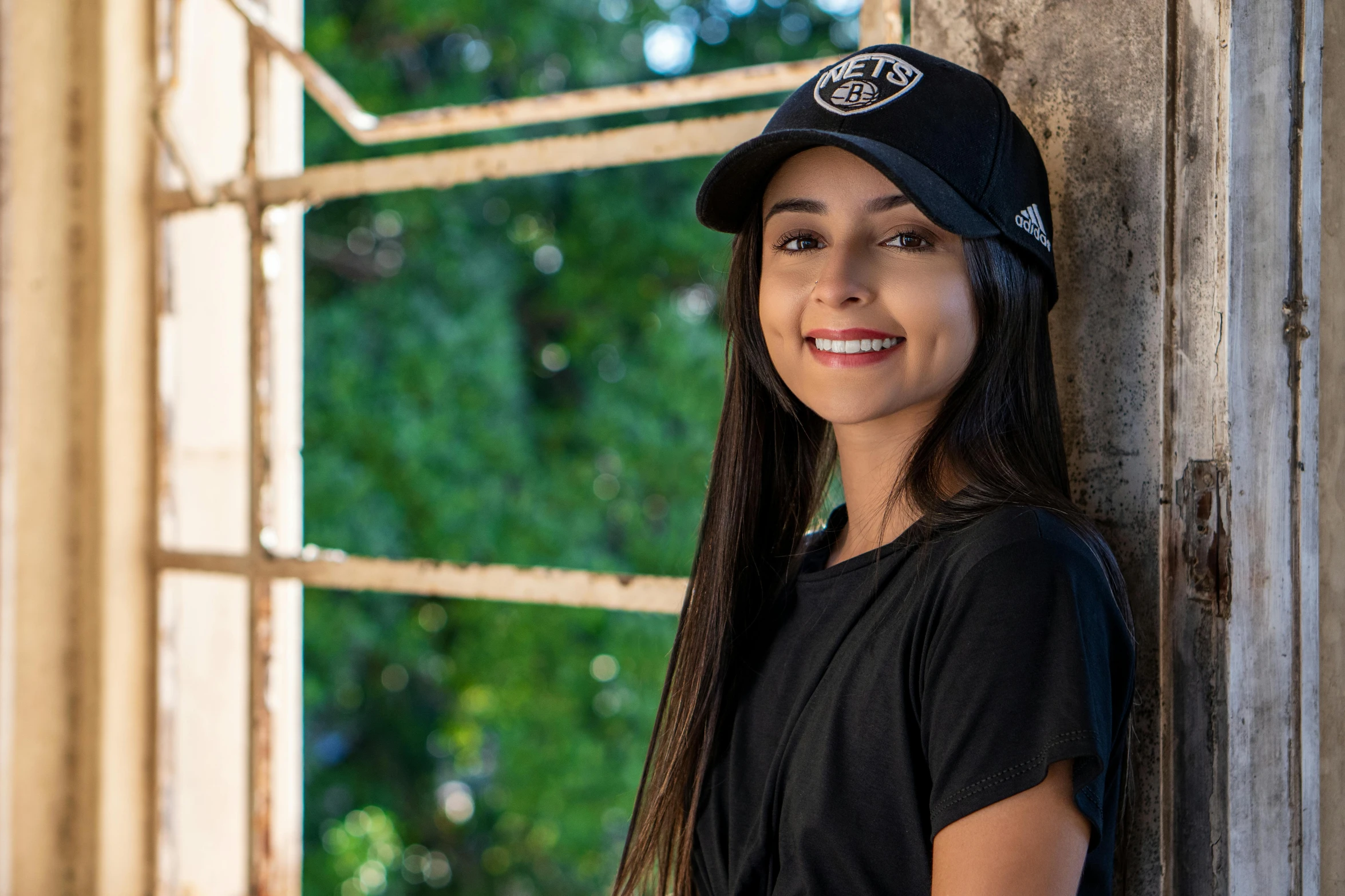 a woman in black shirt and hat leaning on window