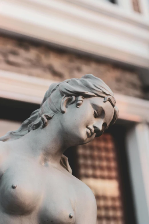 a statue of a female figure in front of a building