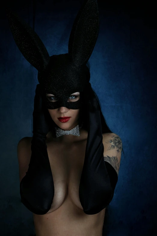 a close up of a person wearing a black bunny mask