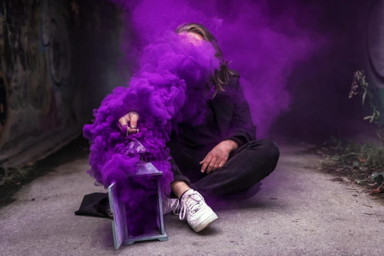 the young man is sitting down on the floor with a bunch of dye