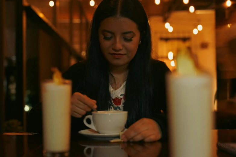 a woman sitting at a table with a cup of coffee