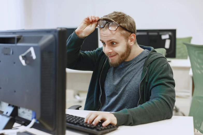 a man with glasses looking at a computer screen