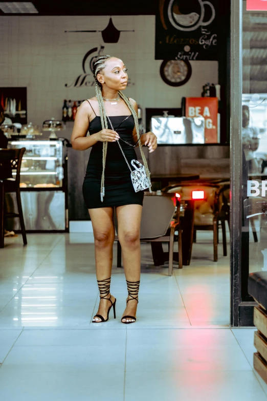 a woman is standing at a cafe and is posing for the camera