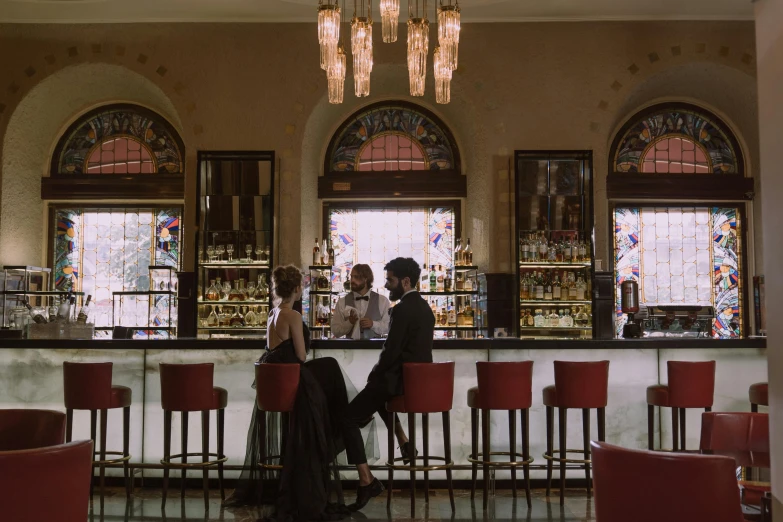 three people sitting at a bar in a el