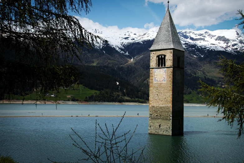 a tower stands next to a body of water