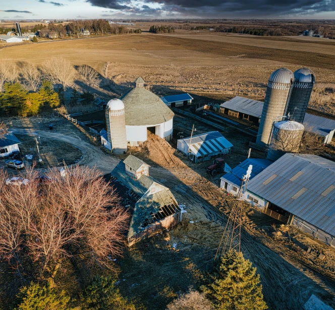 an aerial view of some farm buildings and other buildings in the country side