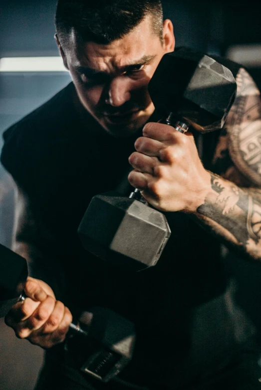 a man holding a pair of grey dumbbells