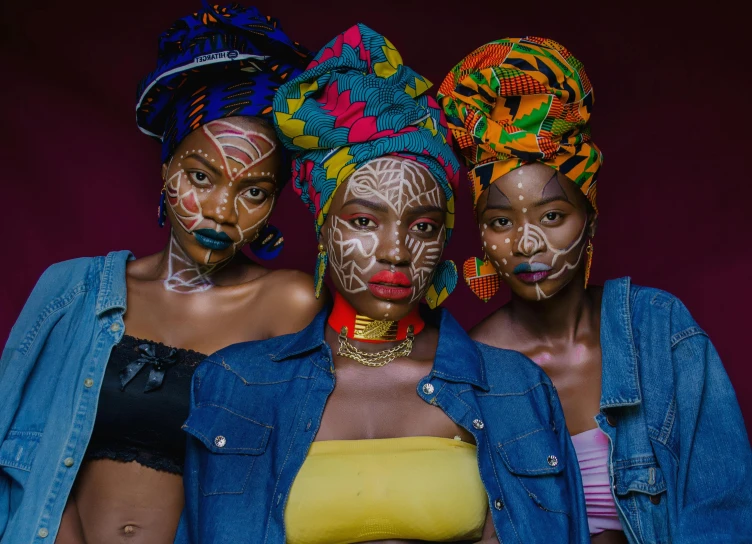 three woman pose with face painting painted on them