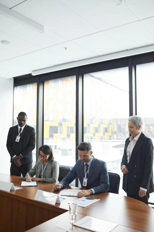 business people sitting around a wooden conference table