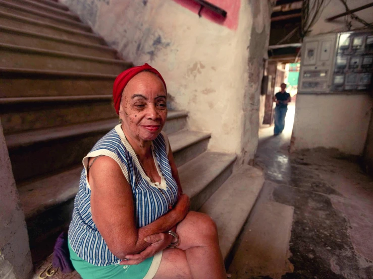 a woman sitting on some steps next to a set of stairs