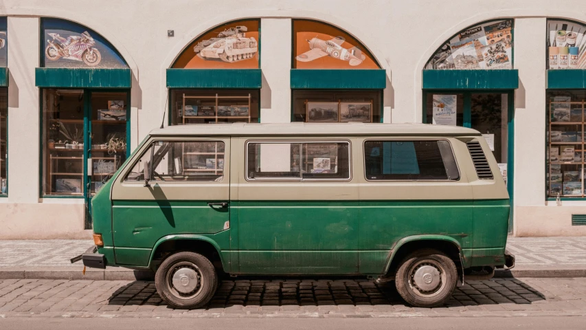 a green car parked outside a building in the city