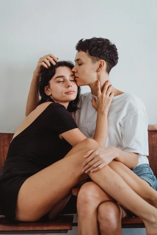 a couple that are sitting on a wooden bench