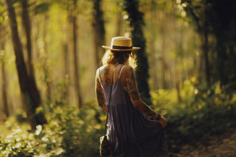 a person with a hat walking alone in the woods