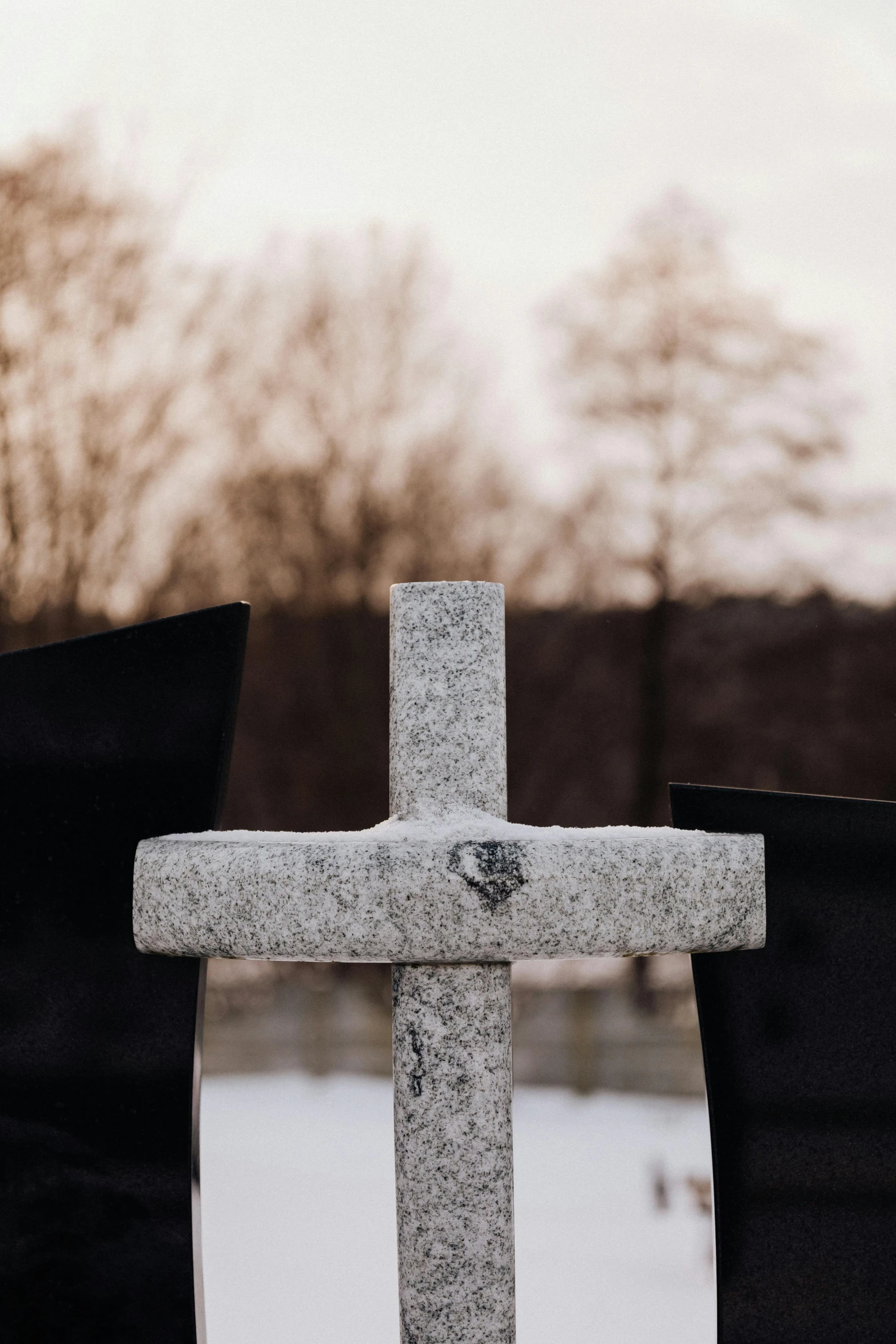 a stone cross is sitting in the snow