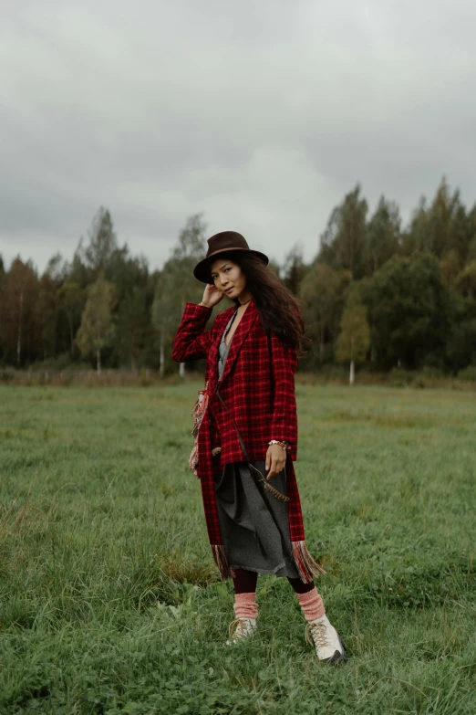 a woman in plaid coat and red hat talking on the phone