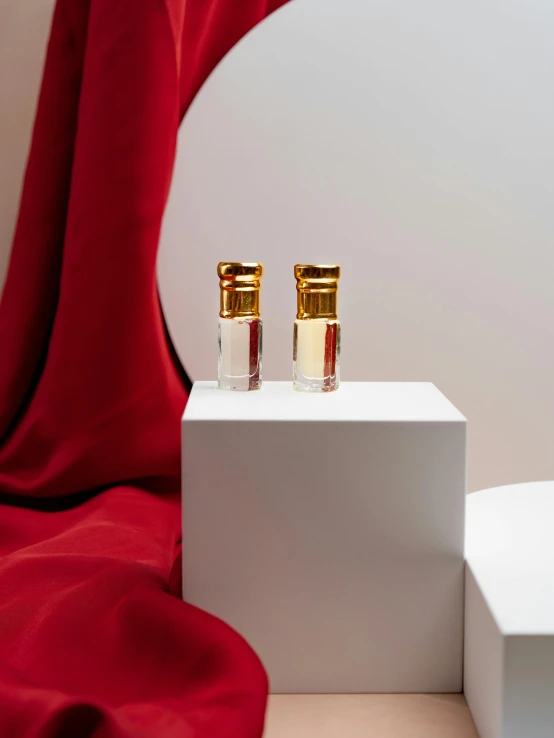 a white podium with two bottles of perfume on top of it