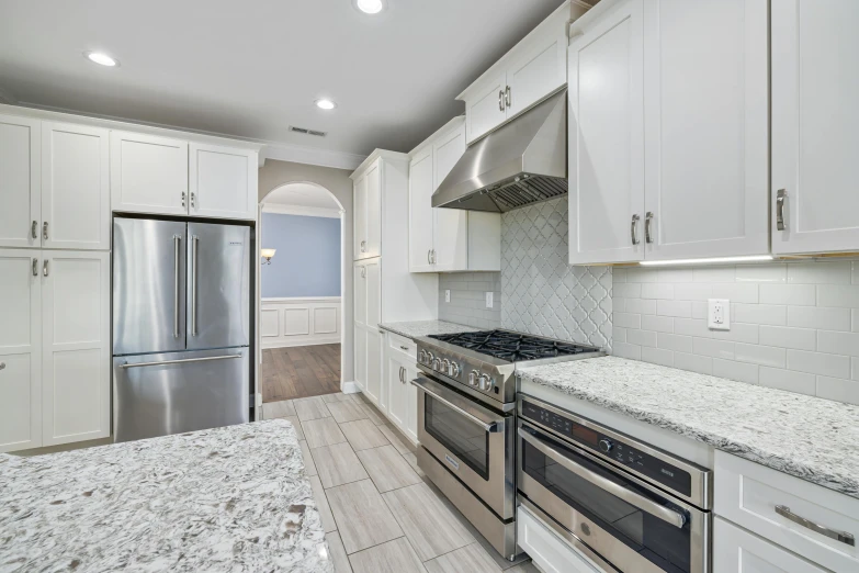 an empty kitchen has all white cabinets and granite counters