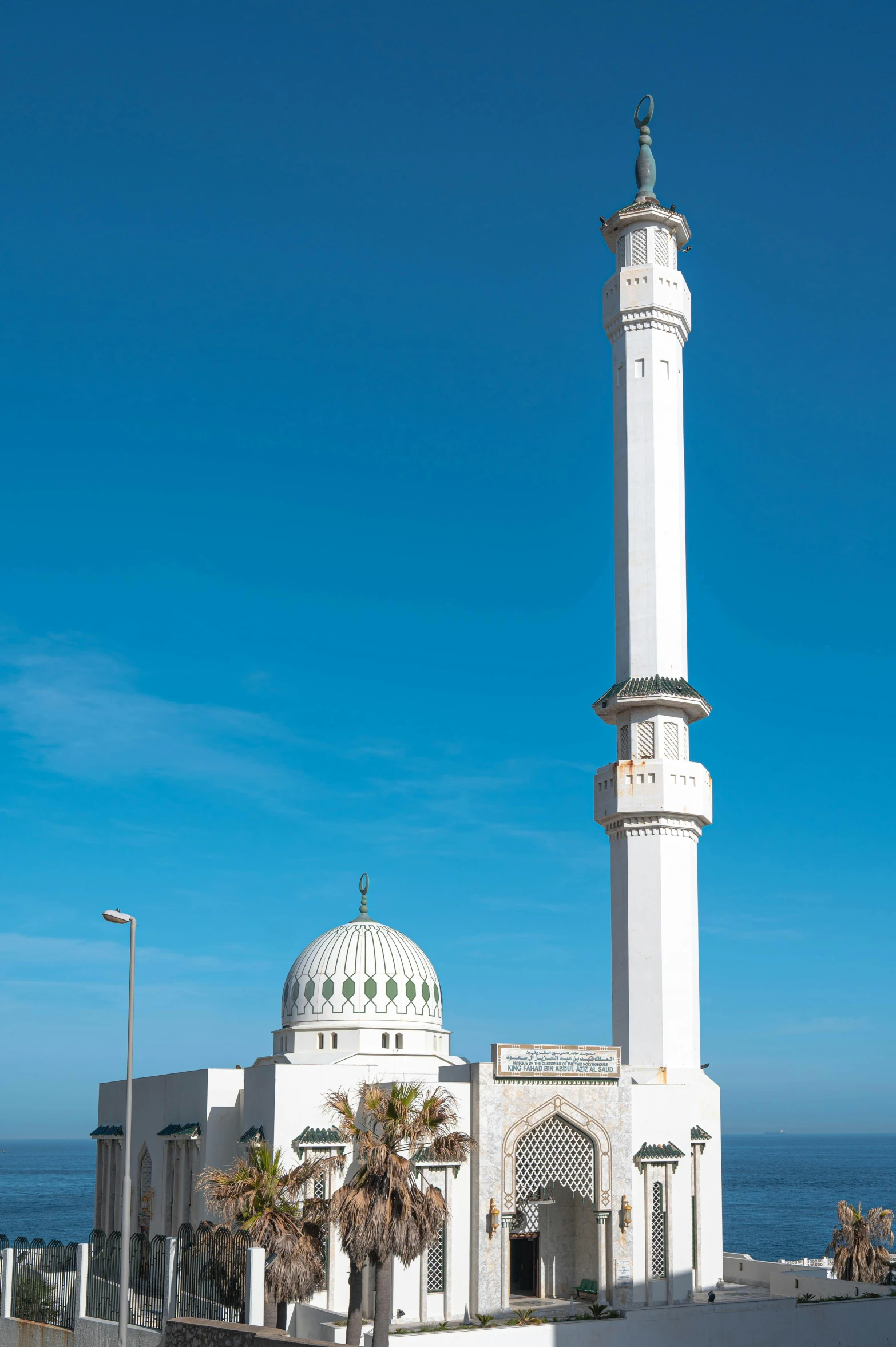 a tall white building sitting next to the ocean