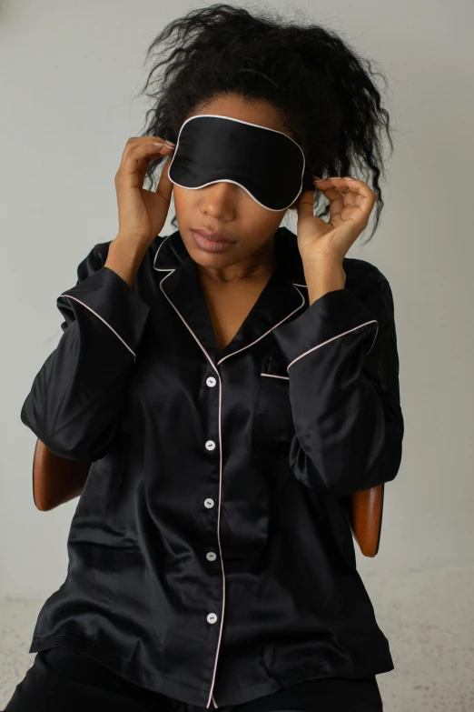 a woman wearing a black blindfold and posing for the camera