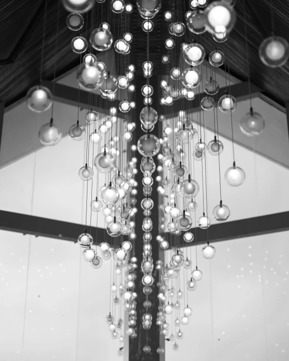 a chandelier with large hanging balls and lights inside a building