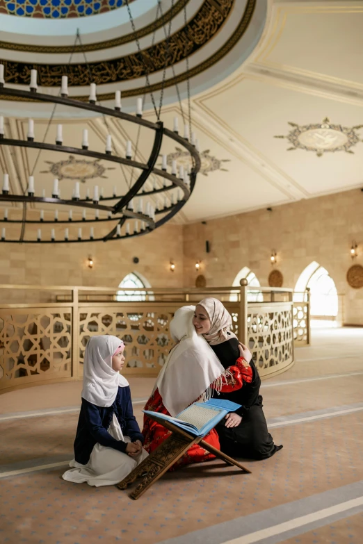 a bride and her two ladies dressed in traditional arabic clothing sitting on the floor