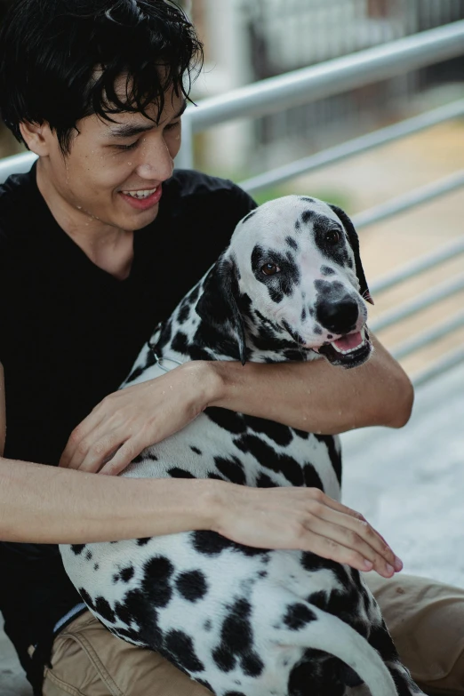 a smiling boy holding a dalmation dog