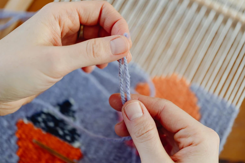 a hand is stitching a piece of fabric