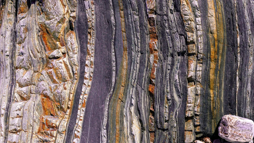 a rock in front of a colorful mountain