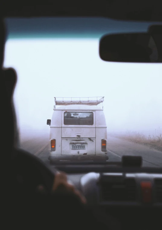 a van with a surfboard on top of it in the middle of nowhere