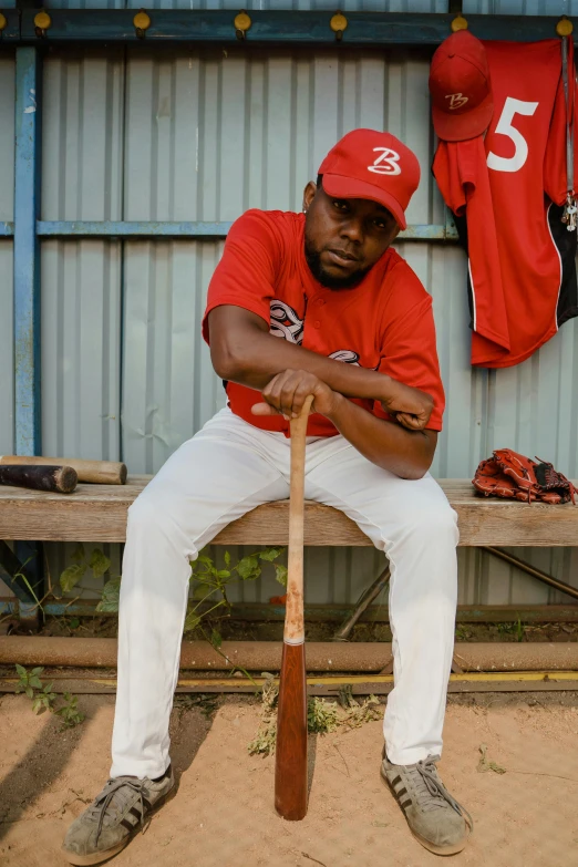 a baseball player in the dugout holding his bat