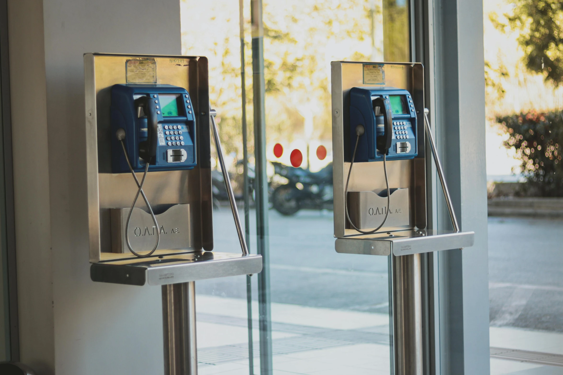 two old style phone mounted to glass doors