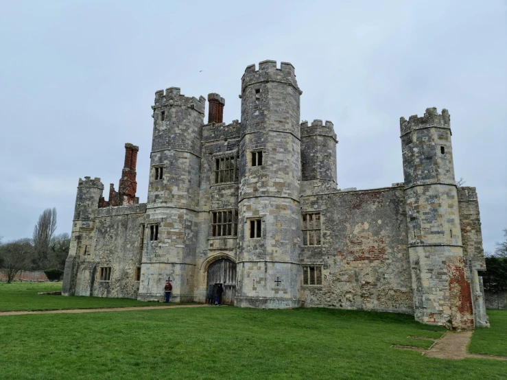 an old castle on top of a green hill