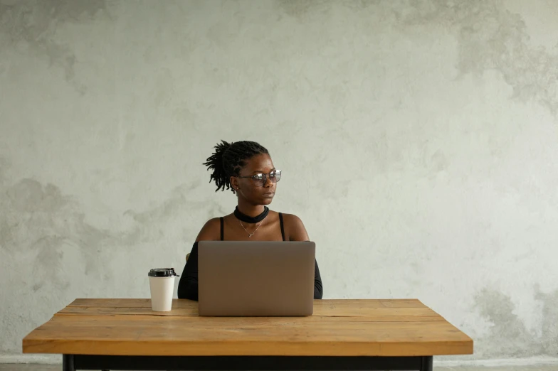 a woman at a table on her laptop and with coffee