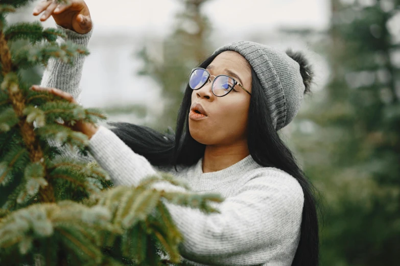 young woman reaching out for the christmas tree