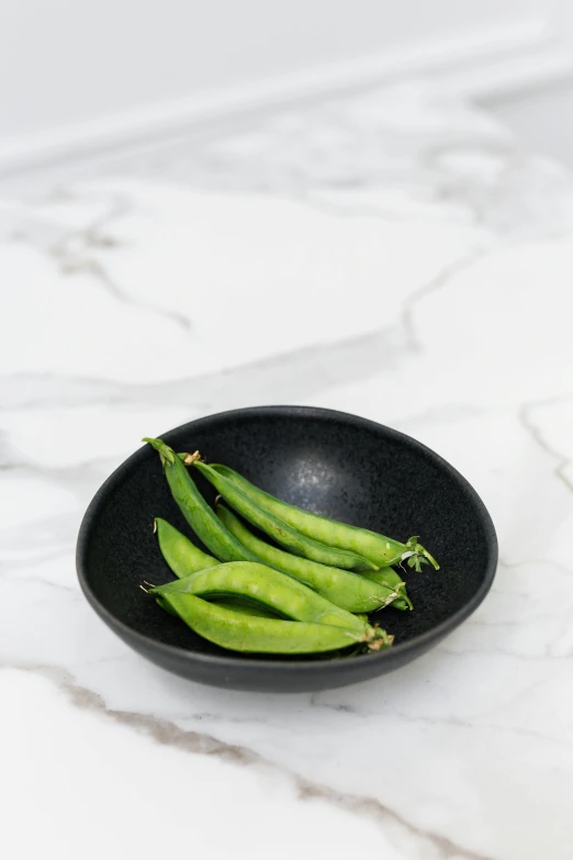 asparagus spears in a bowl on a marble counter