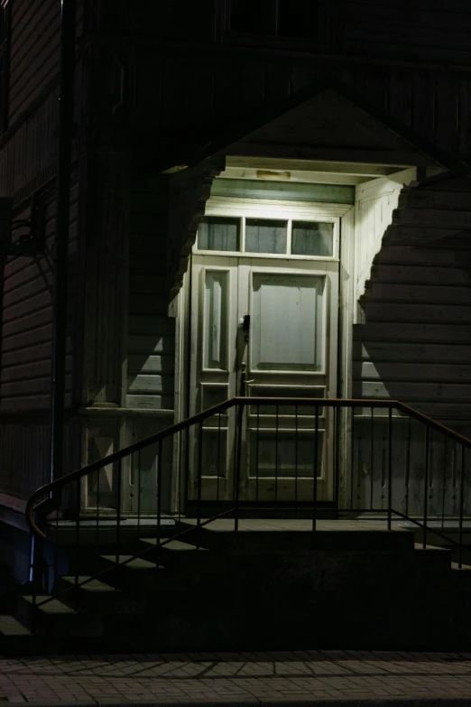 a doorway is lit up with light by stairs