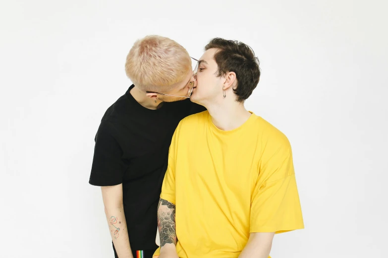 two boys sharing a kiss while wearing yellow shirts