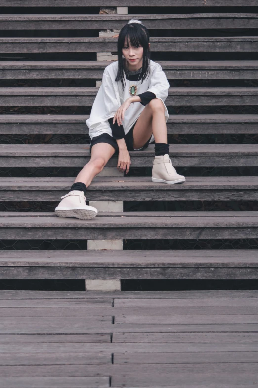 a woman with dark hair sitting on steps