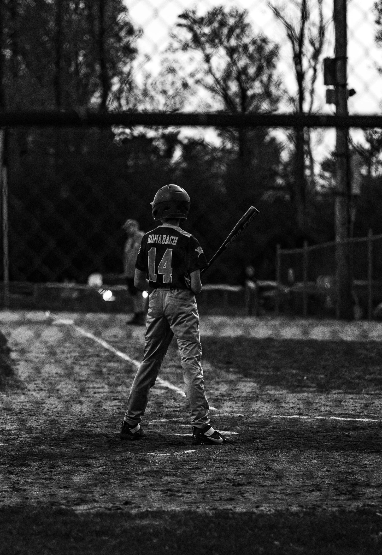 a young man holding a baseball bat standing next to home plate