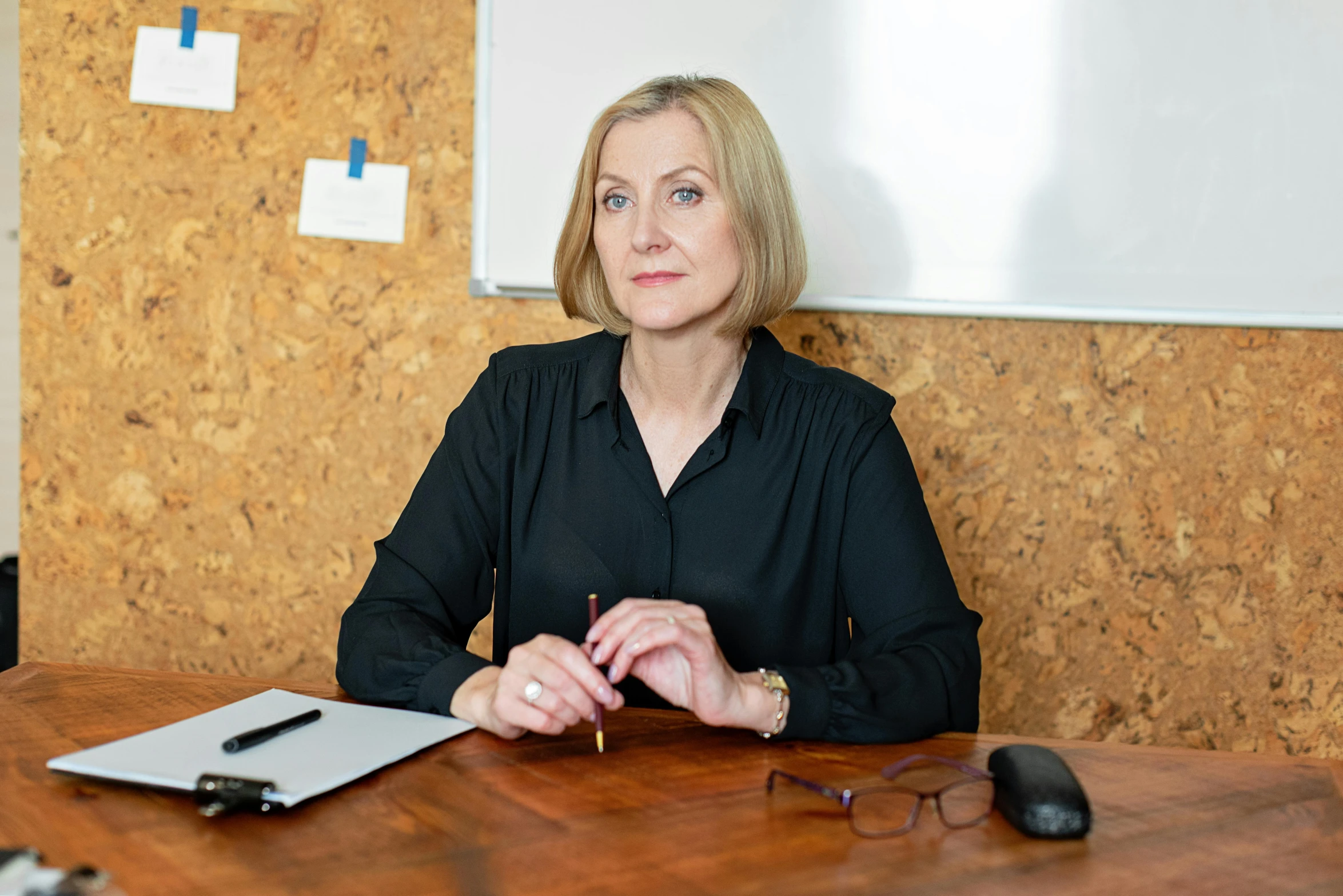 a woman sitting at a desk with a tablet in front of her