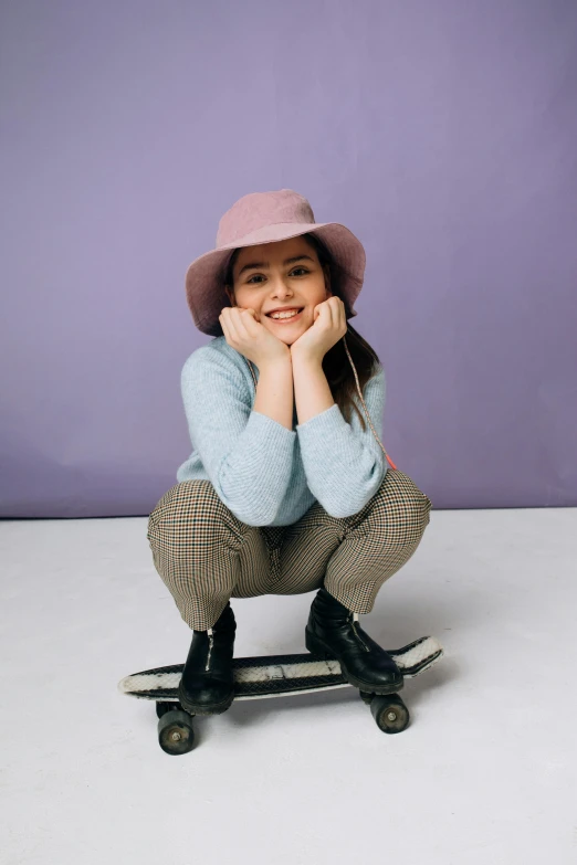 a little girl sitting on a skate board