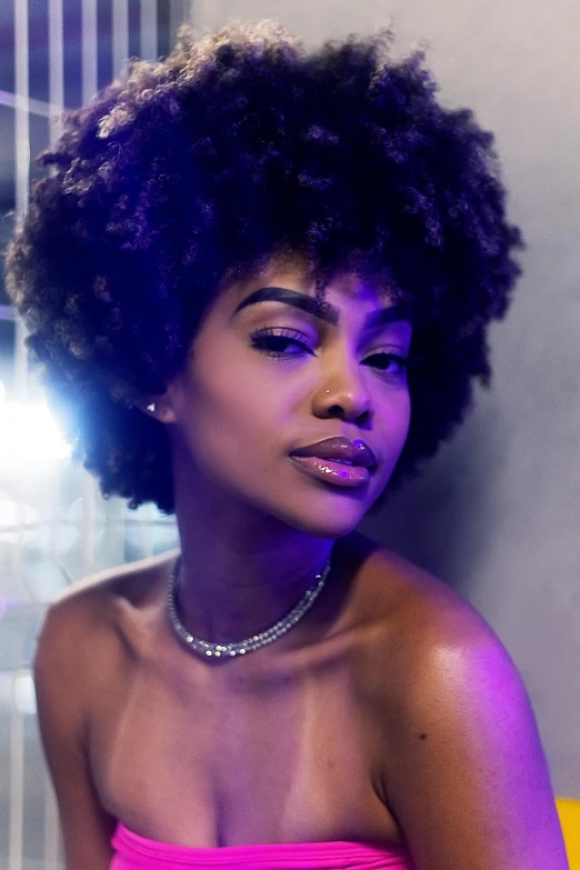 an african american woman in a pink tube top and diamond necklace