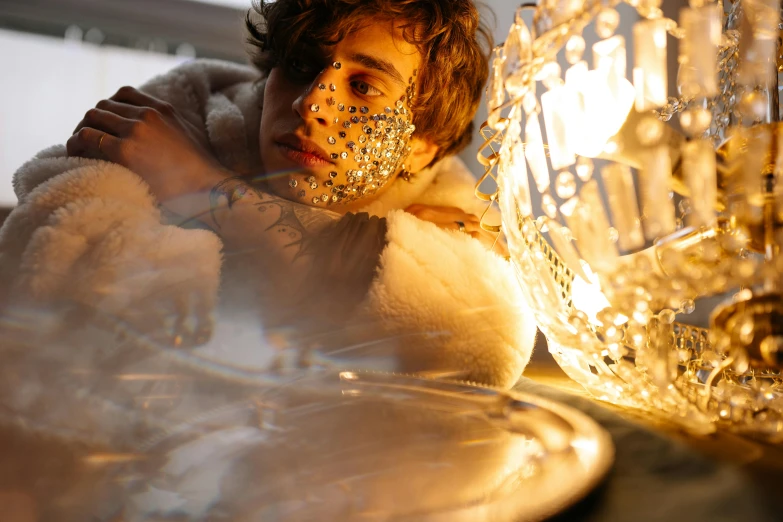 a man with face paint standing next to some lights