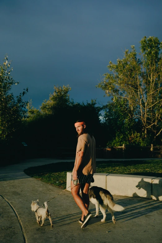 a man on a skateboard with two dogs