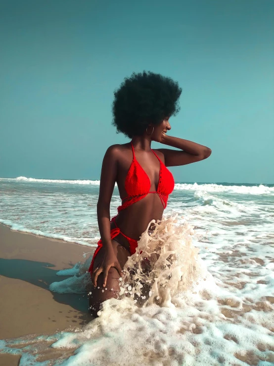 a woman sitting in the waves at the beach