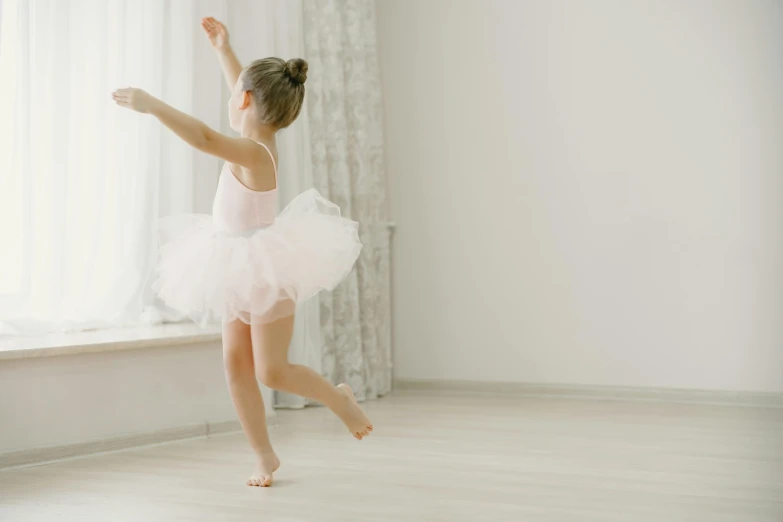 a little girl in a ballet outfit running into a window